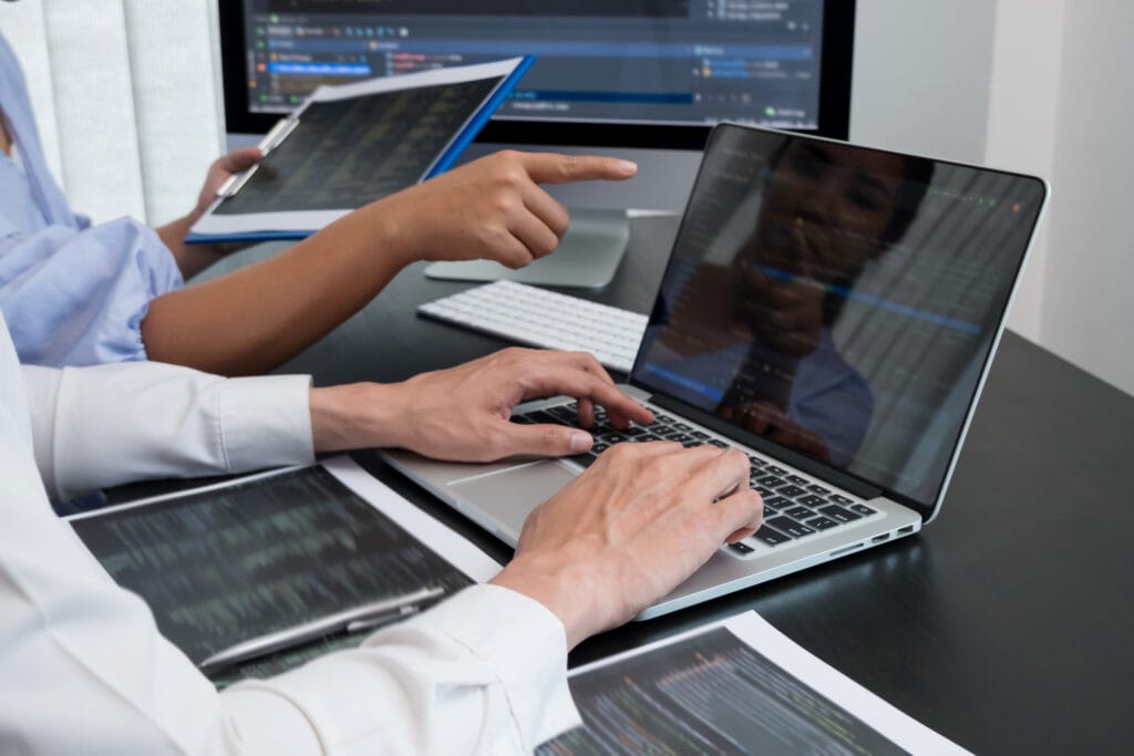 Team of programmers working with computer programming, professional development, and coding technology for an artificial intelligence project.
