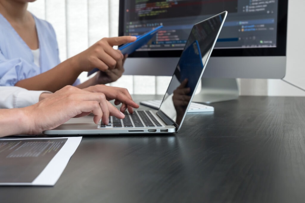 Team of programmers working with computer programming, professional development, and coding technology for an artificial intelligence project.