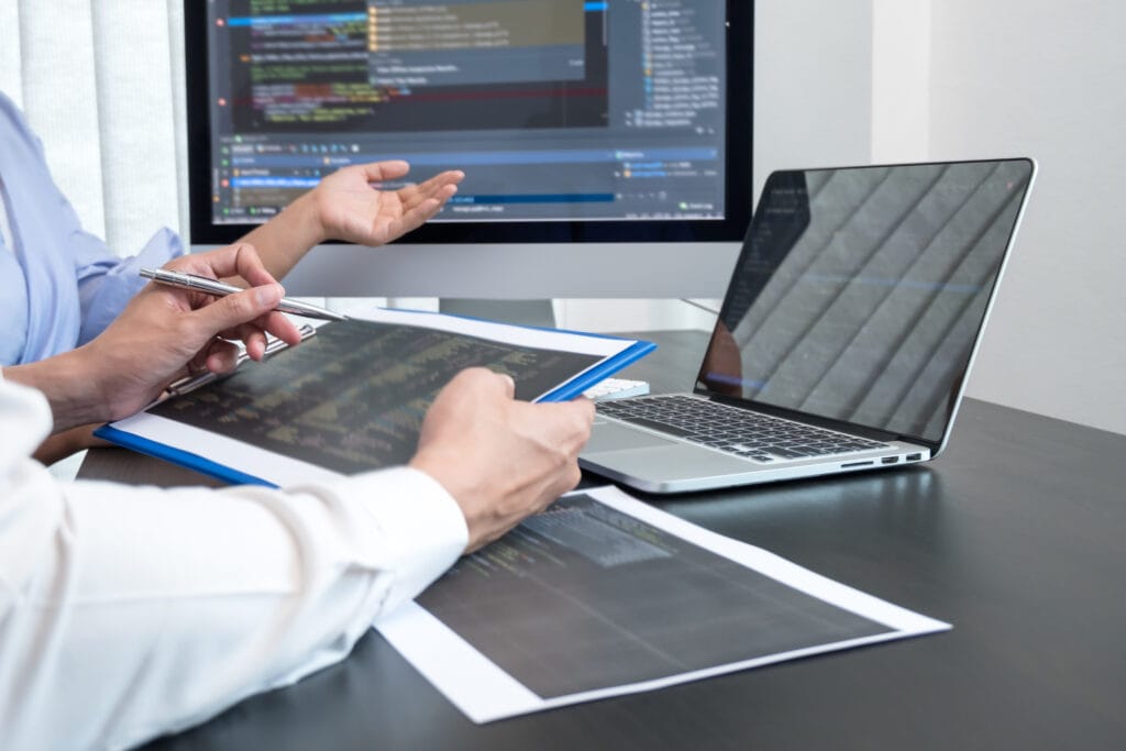 Team of programmers working with computer programming, professional development, and coding technology for an artificial intelligence project.