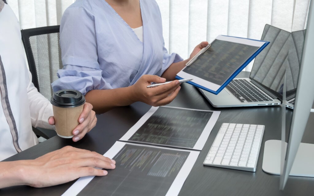 Team of programmers working with computer programming, professional development, and coding technology for an artificial intelligence project.